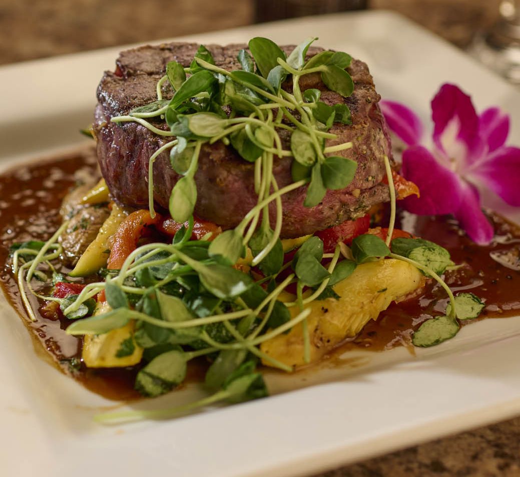 A deliciously prepared filet mignon with micro greens and seasonal vegetables